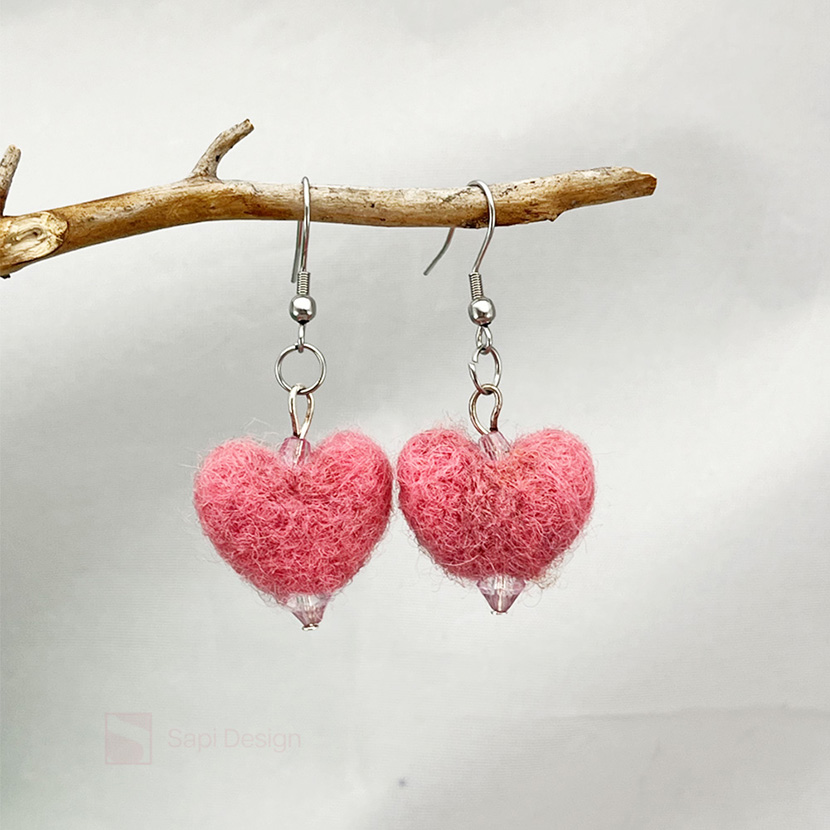 Käsin lampaanvillasta huovutetut vaaleanpunaiset sydänkorvakorut